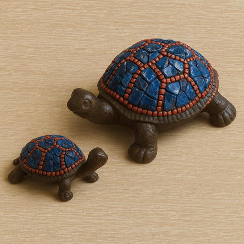 Two turtle figurines with mosaic-patterned shells on a wooden surface