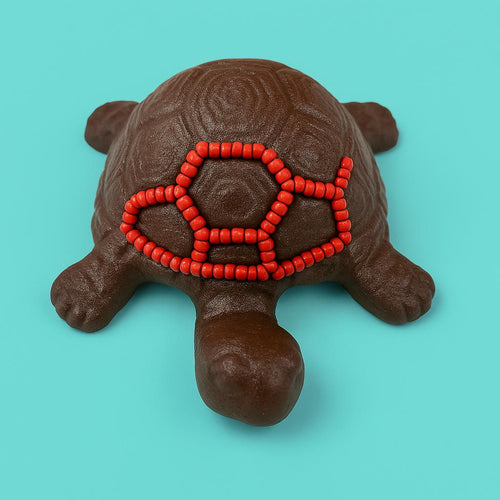 Cast iron turtle with glass  beads on a turquoise background